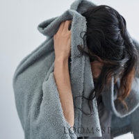 一位人士用灰色蓬鬆毛巾擦拭頭髮，毛巾質感柔軟，呈現出舒適的居家氛圍。