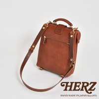 職人手作皮革迷你包，經典棕色，軟皮材質，設有拉鍊口袋、可調節肩帶及金屬扣環，適合隨身攜帶。