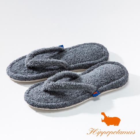 一雙灰色竹棉混紡人字夾腳室內拖鞋，絨毛材質，鞋底邊緣有藍色縫線，右腳拖鞋旁有橘色河馬Logo和品牌名稱。