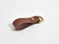 棕色皮革製成的吊掛扣帶，搭配黃銅色金屬環和卯釘，適合鑰匙圈或吊飾。