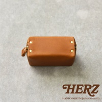 職人手作皮革Organ箱型收納包，採用溫潤的焦糖色皮革，搭配精緻的金色拉鍊和鉚釘，整體呈現簡約大方的質感。