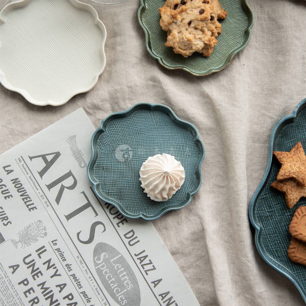 美濃燒花型甜點盤，由陶瓷製成，表面有細緻的格紋紋理。此圖顯示了白色、綠色和藍色三種顏色的盤子，其中藍色盤子內放有白色蛋白霜，綠色盤子內有餅乾，右側藍色盤子內有造型餅乾。