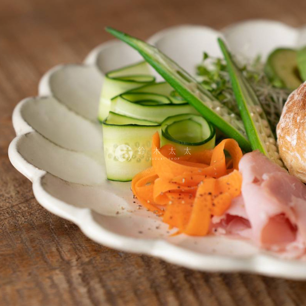 白色陶瓷主食盤，帶有粉引釉色和花型邊緣，盛有切片的黃瓜、胡蘿蔔絲、秋葵、火腿片和麵包。