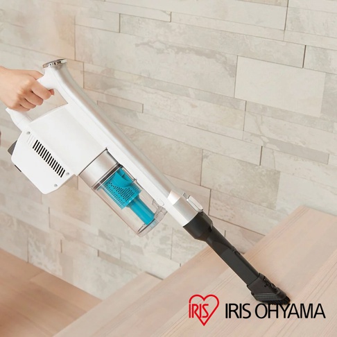 手持銀白色氣旋式無線吸塵器，配有透明集塵筒和藍色濾網，黑色吸頭，正在清潔木質樓梯。