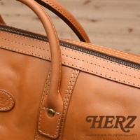 職人手作皮革波士頓包，採用柔軟的棕褐色皮革，搭配精緻縫線，設有拉鍊開合和舒適的提把。