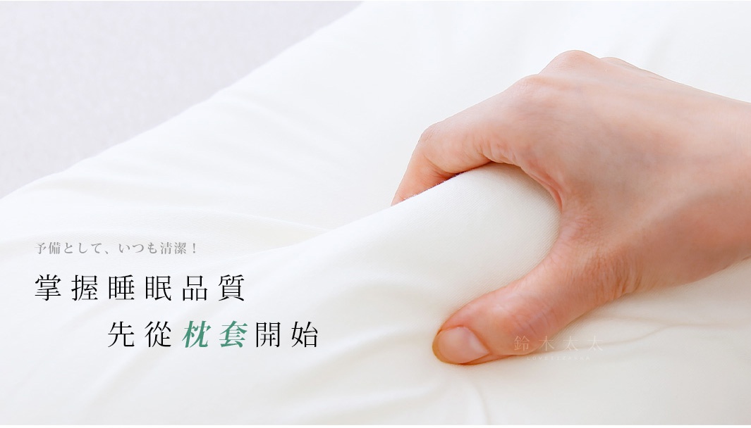 一隻手正在擠壓純白色棉布枕套，展示其柔軟和彈性。