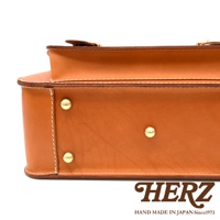 職人手作皮革經典雙扣兩用單肩包，採用光滑的棕褐色皮革製成，配有金屬釘和縫線細節。