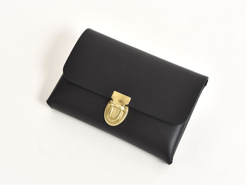 黑色皮革製成的手作小卡片收納夾，配有金色金屬鎖扣，設計簡約。