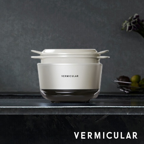 淺米色 Vermicular IH 琺瑯鑄鐵鍋，配有同色系鍋蓋，鍋身中間有黑色飾帶，頂部有兩個把手。