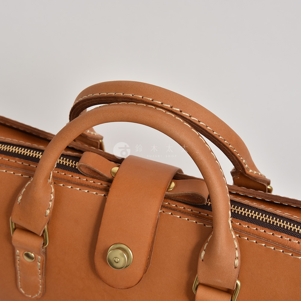 職人手作皮革三層收納兩用商務公事包，採用淺棕色皮革，搭配金屬拉鍊與旋鈕扣，縫線清晰。