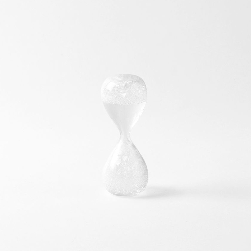 awaglass mini 泡時計，玻璃材質，呈沙漏狀，上半部裝有白色液體和氣泡，下半部同樣有氣泡，整體為透明白色。