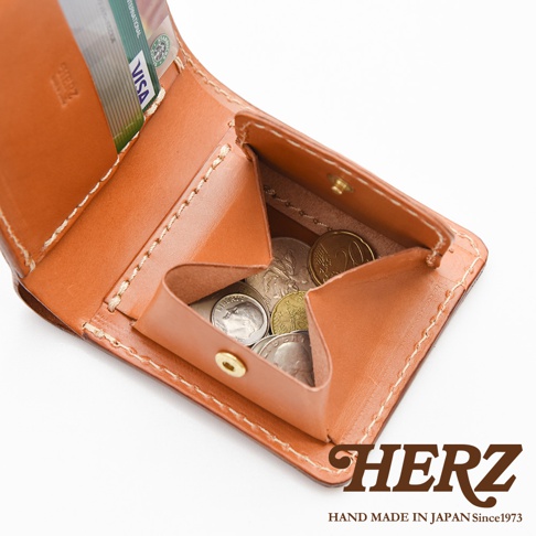 職人手作皮革經典雙折短夾，展示打開的狀態，內有硬幣和信用卡。錢夾為棕褐色皮革材質，縫線清晰。