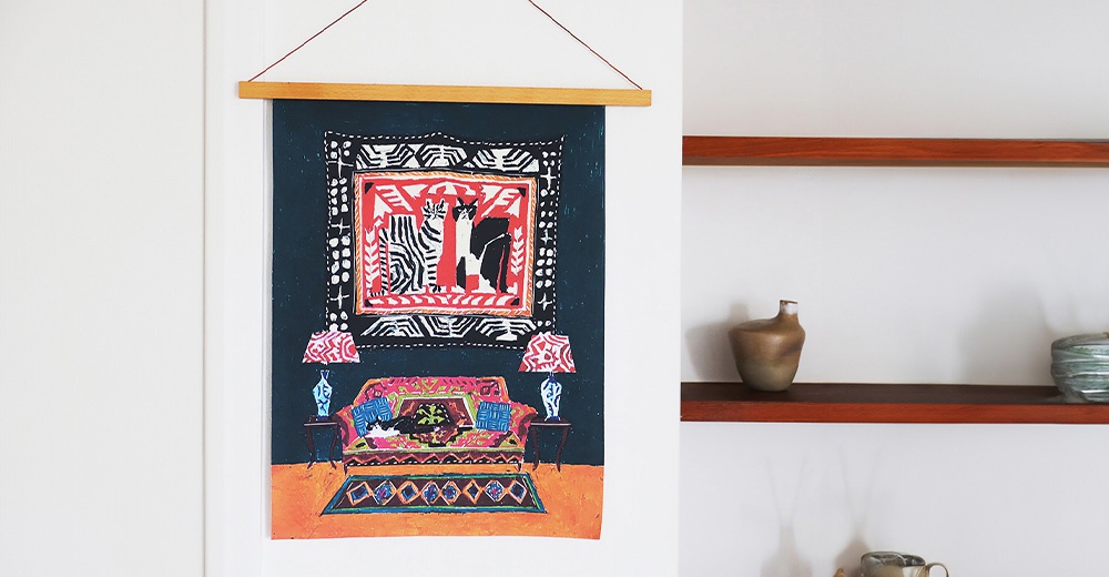 無框帆布藝術海報，描繪一間佈置溫馨的房間，畫面中有兩隻貓咪，一張色彩鮮豔的沙發，兩盞風格獨特的檯燈，以及一塊幾何圖案的地毯。整體色調以深藍、紅色、粉紅和橘色為主，材質為帆布。