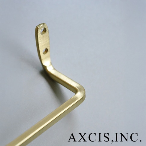 AXCIS, INC. 標誌旁的黃銅毛巾架局部，呈現金屬光澤與簡約設計。