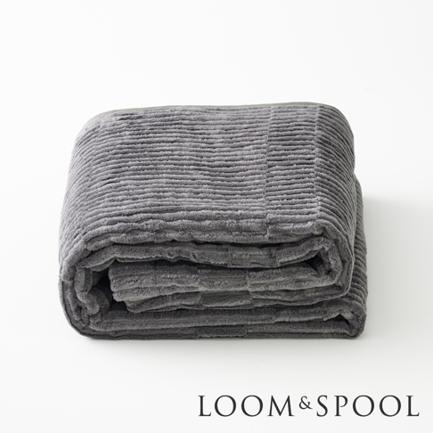 GRAU 立體直紋純棉微厚單人毯，呈現深灰色，織物表面有明顯的直條紋理，毯子對折堆疊，質感柔軟。