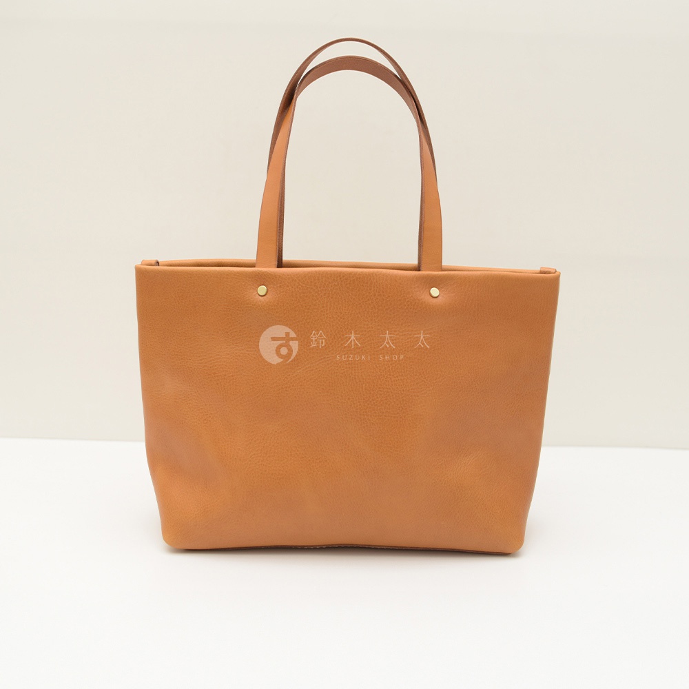 職人手作皮革4口袋極簡托特包 T-3，採用柔軟的棕褐色皮革製作，簡潔的設計配有兩條皮革提把，包身正面中央壓印有品牌標誌。