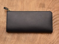 職人手作皮革Organ雙拉鍊L型長夾，黑色牛皮材質，L型開口設計，配有金色拉鍊及同色系皮革拉頭，置於木紋背景上。