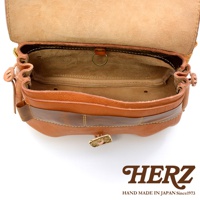 職人手作皮革鹿角扣繩郵差包，棕色皮革，打開狀態，展示內部空間，有縫線細節與金屬環，包款有鹿角造型的扣飾。