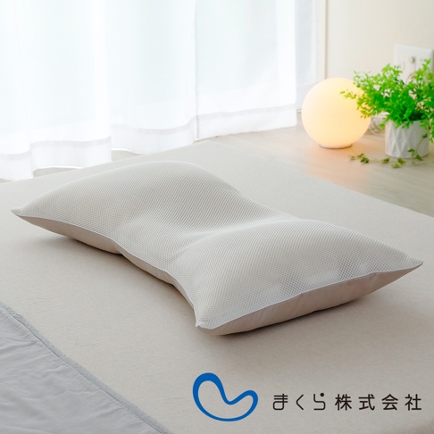 一款白色網狀材質的低枕，具有人體工學的曲線設計，能貼合頸部與頭部。枕套為米白色，整體呈現簡潔乾淨的風格。