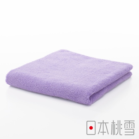 一條淺紫色、柔軟的居家毛巾，材質為棉，邊緣有縫線，平整疊放在白色背景上。