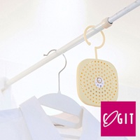 日製可掛式長效除臭防霉除濕貼片盒，淺黃色方形塑料盒，表面布滿圓形透氣孔，中央有可愛獅子圖案，附有掛環，懸掛於白色吊桿上，下方有白色衣物和衣架。