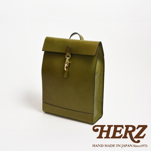 橄欖綠皮革後背包，紙袋造型，翻蓋設計，配有金色鉤扣和皮革繫帶，簡約實用。