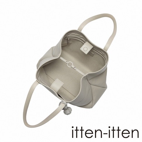 一款淺灰色 itten-itten Neru 義大利皮革托特包，以俯視視角呈現，展示包內空間結構與細緻的皮革紋理，包身側邊裝飾有特色點結吊飾。