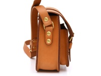 全皮革製作的棕色單肩包，側面展示，配有金屬鉚釘和可調節肩帶。