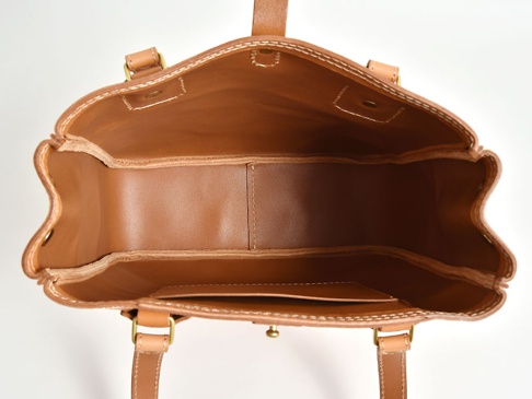 職人手作皮革原子釦托特包，採用棕色天然皮革製成，內部結構清晰，可見多個隔層和口袋，搭配金屬釦件及縫線細節。