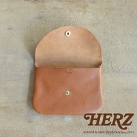 職人手作的棕色皮革小物收納袋，掀蓋式設計，附有金屬鈕扣。袋面壓印「Organ」字樣，材質呈現皮革自然紋理。