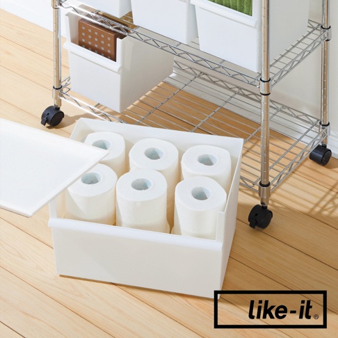 白色塑膠寬型整理收納盒，內含六卷衛生紙，置於金屬層架旁，收納盒旁有一片白色頂蓋。