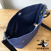 海軍藍刺子織迷你側背包，內有隔層，配有黑色織帶和銀色金屬配件，展現其內裡細節。