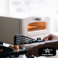 米白色復古多用途烤箱，設有透明觀景窗，內部有烘烤中的吐司，烤箱面板上有溫度和時間旋鈕，以及Sengoku Aladdin品牌標誌。