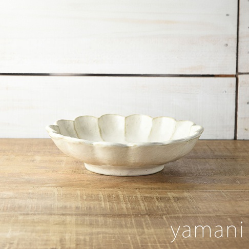 米白色美濃燒六魯粉引沙拉盤，24公分，帶有明顯的扇形花瓣狀邊緣，盤身呈現自然手作質感，擺放在木質紋理的桌面。