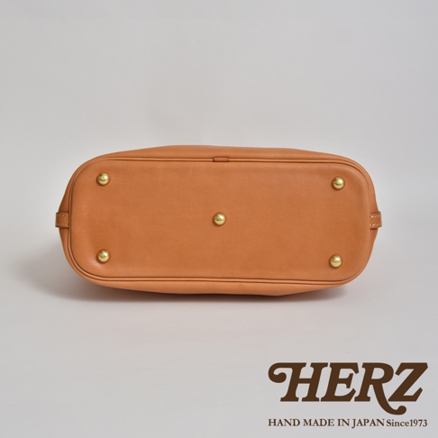 職人手作皮革大容量兩用托特包 T-8，展現自然色澤的皮革材質，底部設有四個金屬腳釘，穩固耐用。