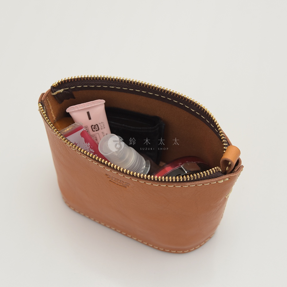 職人手作皮革三角收納包，淺棕色皮革，內含化妝品和噴霧瓶，搭配金色拉鍊。