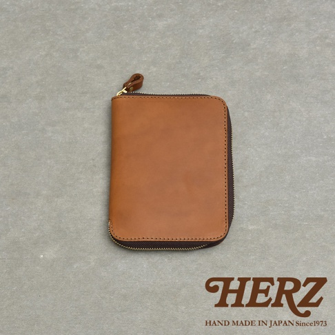 一個關閉拉鍊的棕色皮革記事本收納包，上面有標誌。