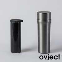 兩個三用保溫瓶，一個為黑色、帶有細緻斑點紋理的圓柱體，頂部配有黑色方形扁平蓋；另一個為銀灰色金屬材質，瓶身光滑，頂部有圓形瓶蓋，整體設計簡約。