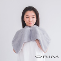 一位女士身穿一件淺灰色、柔軟觸感的吸水毛巾，設計成披肩形狀，可固定於頸部，方便吹乾頭髮。