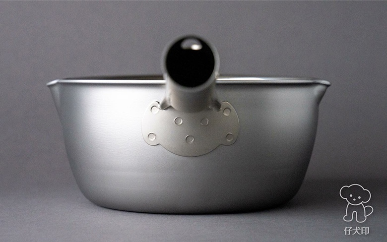 一個18公分的三層不鏽鋼雪平鍋，鍋身呈銀灰色，帶有一個短柄，鍋身側面有兩個小巧的注水口。