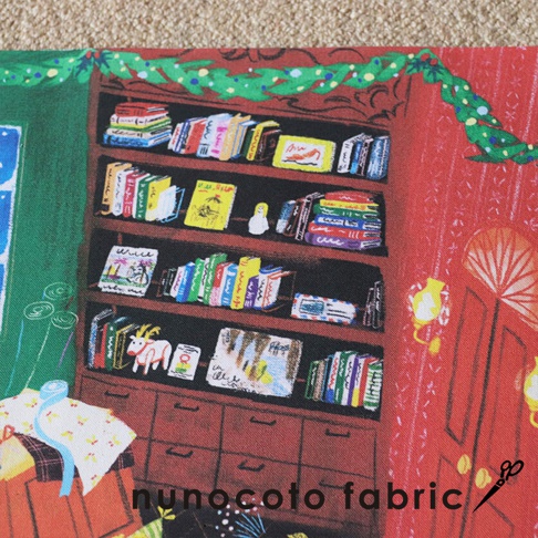 無框帆布藝術海報，描繪聖誕老人玩具工作室場景，有滿架色彩繽紛的書本、一個白色聖誕老人玩偶，以及一個牽著紅色小精靈的白色山羊，背景是綠色聖誕樹藤蔓裝飾的紅色牆壁。