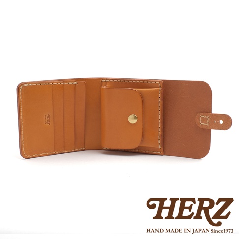 焦糖色皮革對折短夾，內有卡槽與零錢袋，以原子釦開合，手工縫製，展現職人質感。