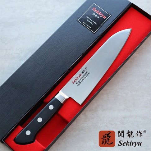 鉬釩不鏽鋼三德刀，刀刃長18公分，配有黑色手柄，以紅色襯裡的黑色禮盒包裝。