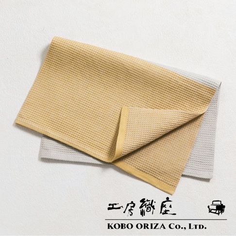 兩條WAFLE棉麻混紡拭巾，一條為芥末黃，另一條為淺灰色，皆帶有鬆餅紋理。