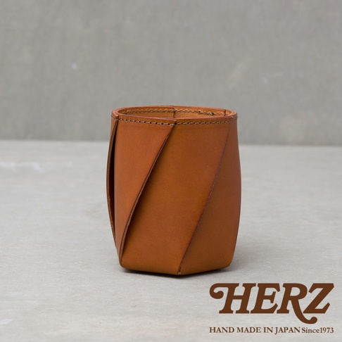 職人手作皮革Organ六角收納筆筒，採用天然皮革製作，呈現溫潤的棕色調，獨特的六角形摺疊設計，簡約實用。