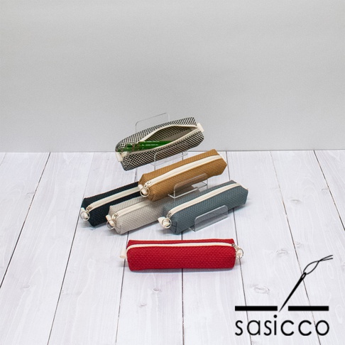 六色三河木綿刺子織筆袋，包括黑白格紋、棕色、灰色、淺灰色、海軍藍和紅色，皆配有拉鍊和掛環，展示於木質背景上。