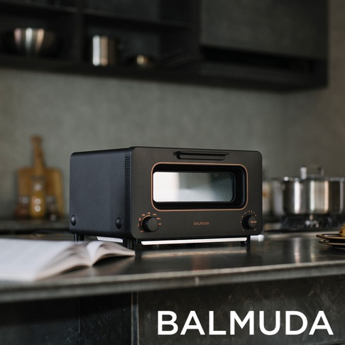 The Toaster 蒸氣烤麵包機，黑色，帶有銅色飾邊的烤箱門和兩個控制旋鈕。