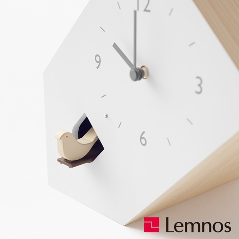 傾斜式布穀鳥房型報時桌鐘，採用白色簡約錶盤，搭配灰色時針、分針和數字時標，錶盤左側設有木質小鳥探出的小屋，側面為淺木色材質。