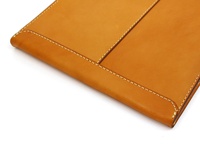 淺棕色皮革信封式手拿袋，邊緣縫線精緻，材質為真皮。