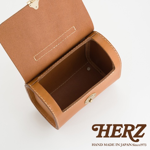 職人手作皮革復古杜勒斯手提包，採用棕色皮革製成，包身圓潤，帶有金色鎖扣和白色車縫線。